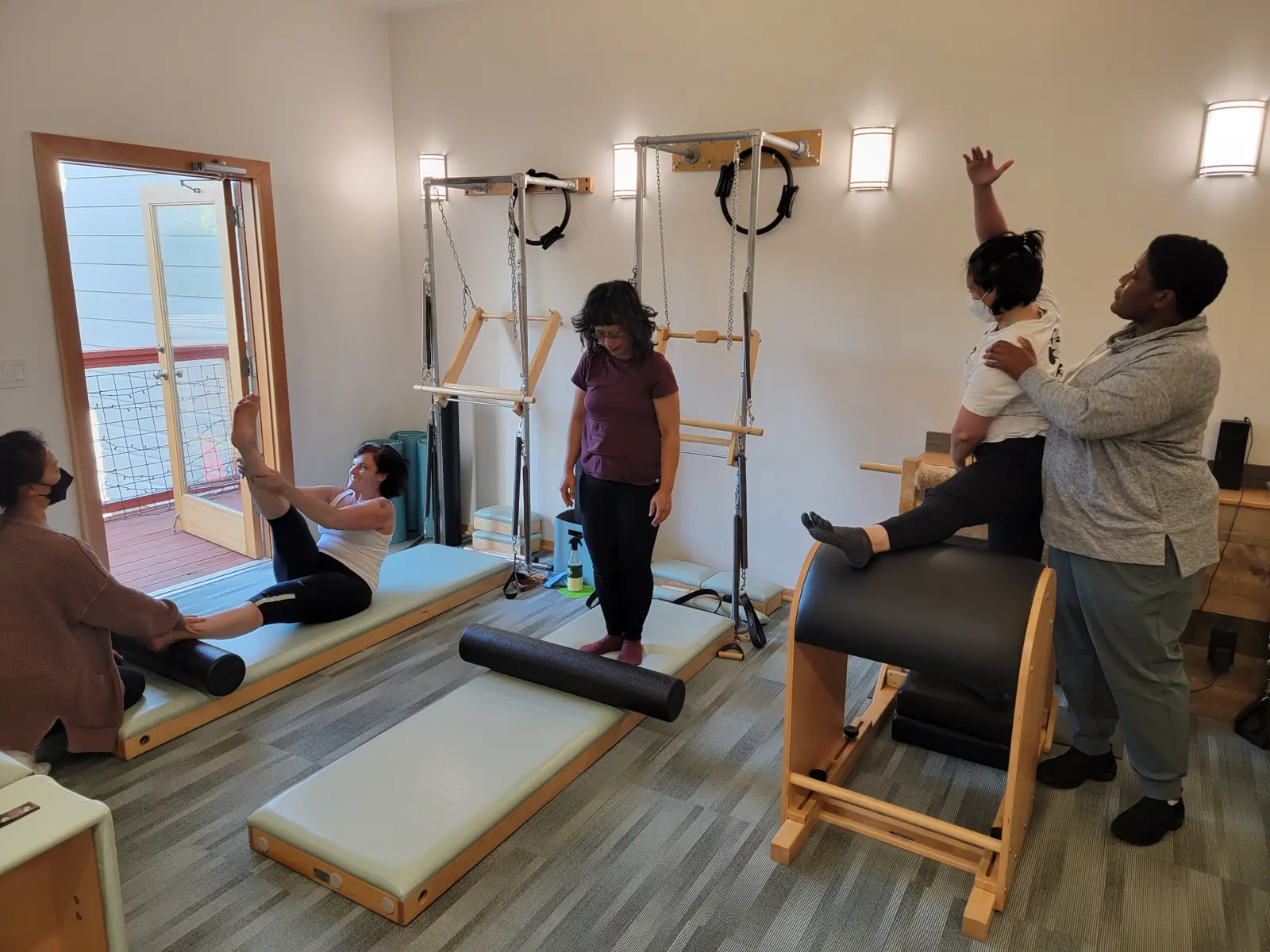 A diverse group of Pilates students learning together