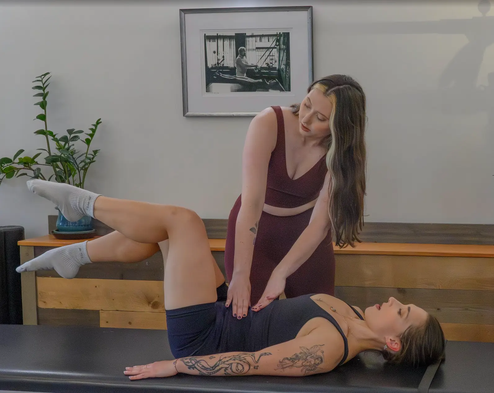 Pilates teacher guiding a student through an exercise