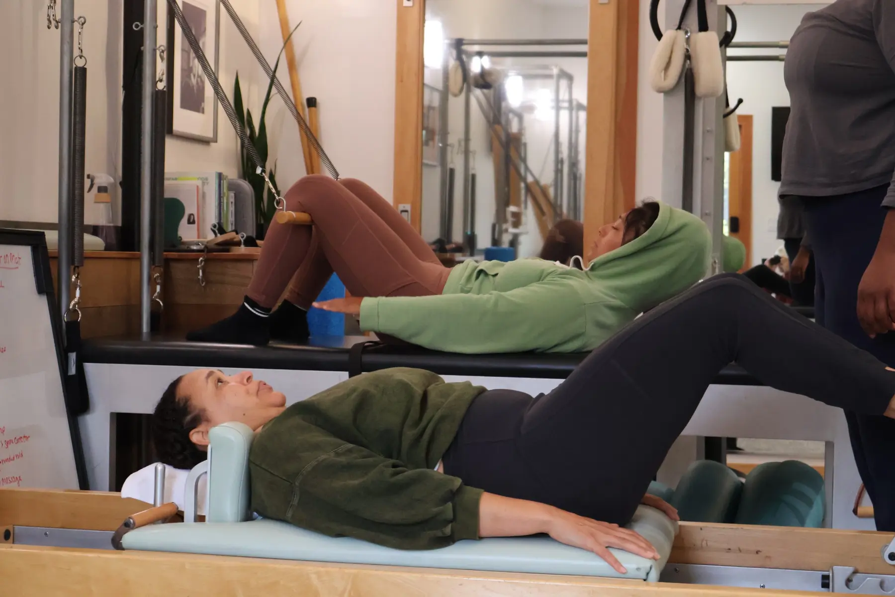 Students practicing on Reformer and Tower equipment in a small group