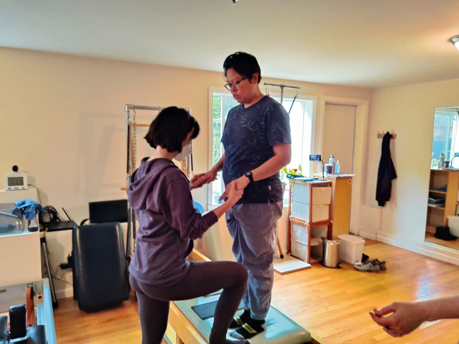 Two students working together during a guided Pilates learning activity