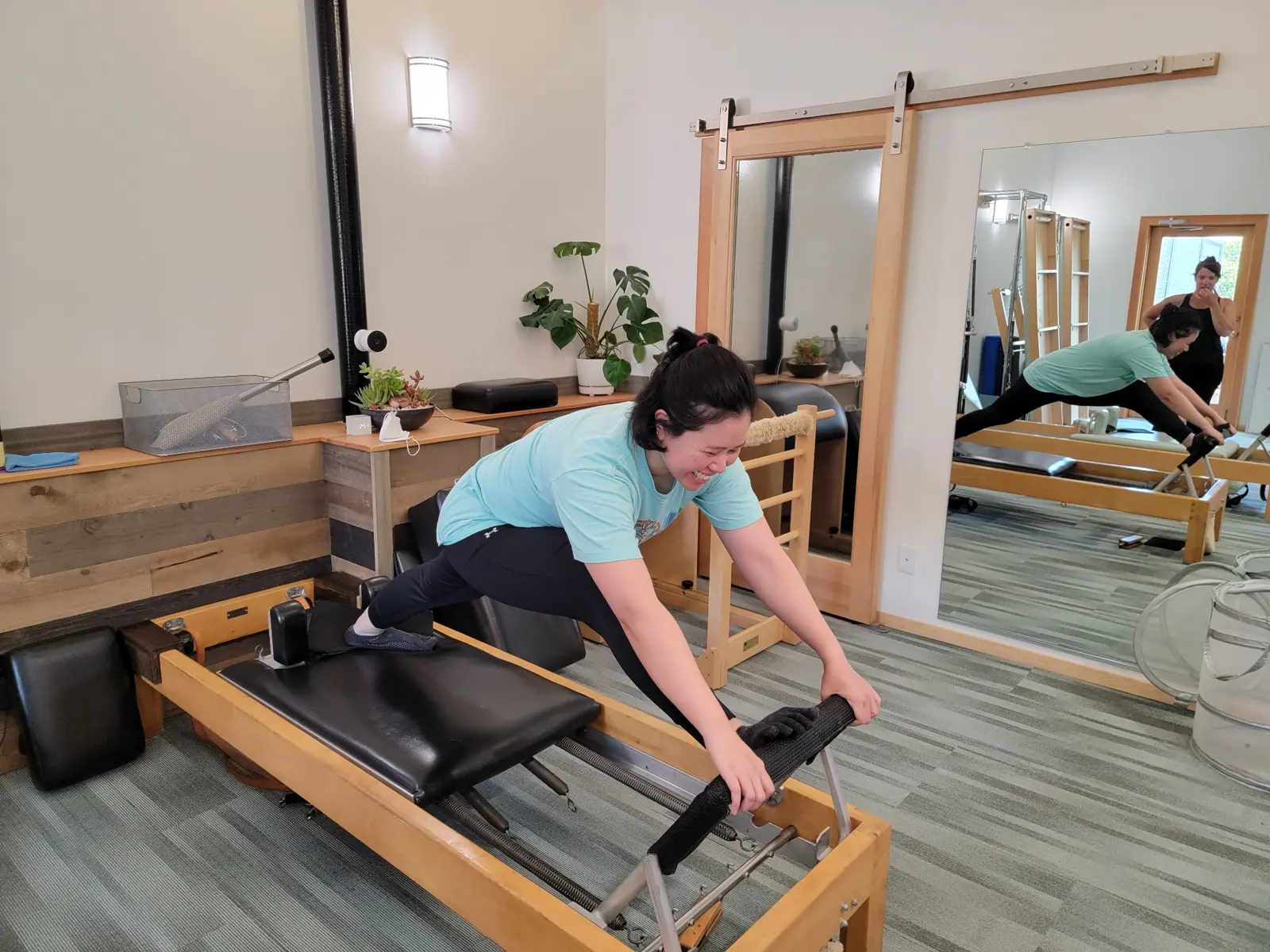 Student smiling while practicing on a Classical Pilates reformer