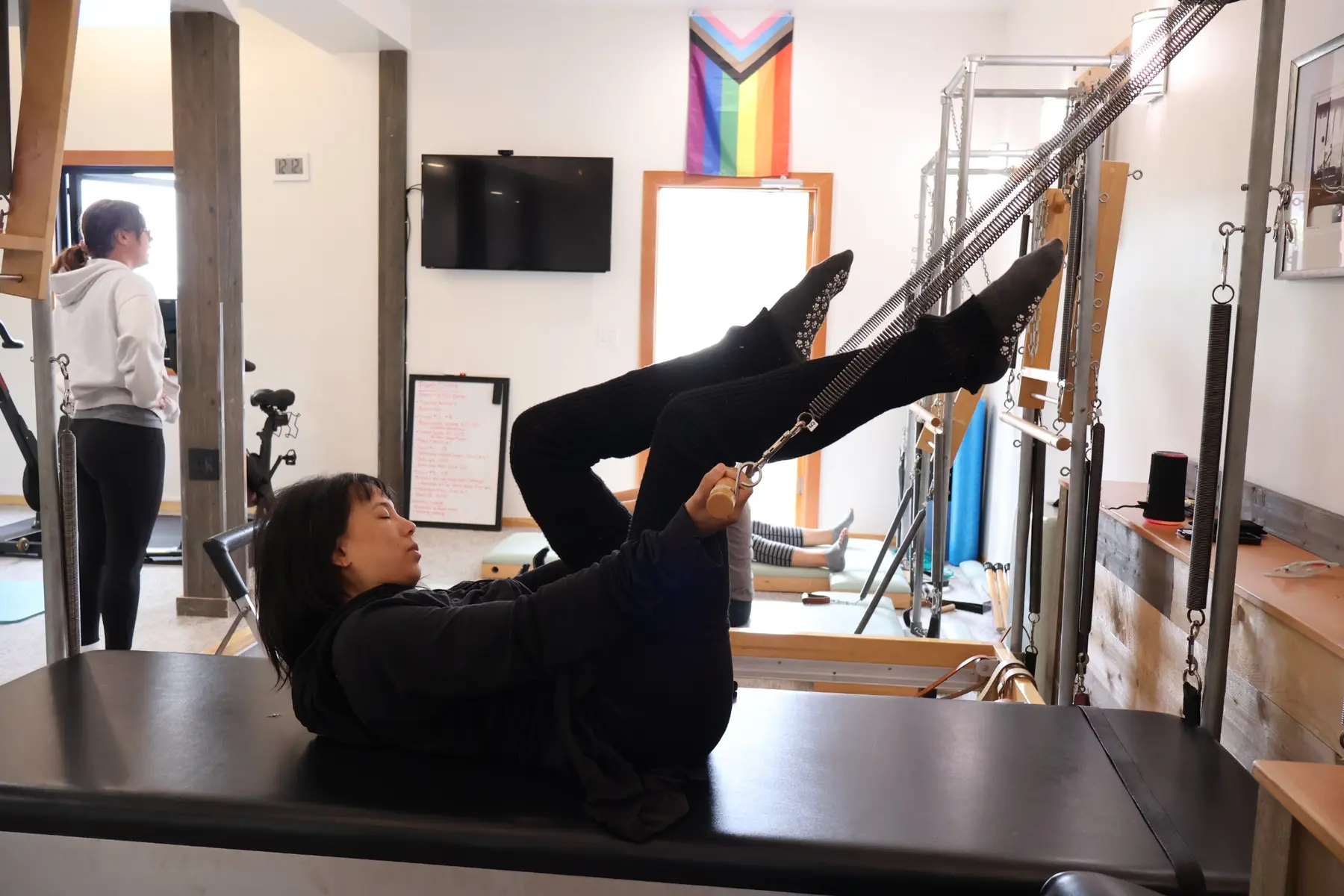 Student practicing spring-assisted leg work on a Pilates Tower
