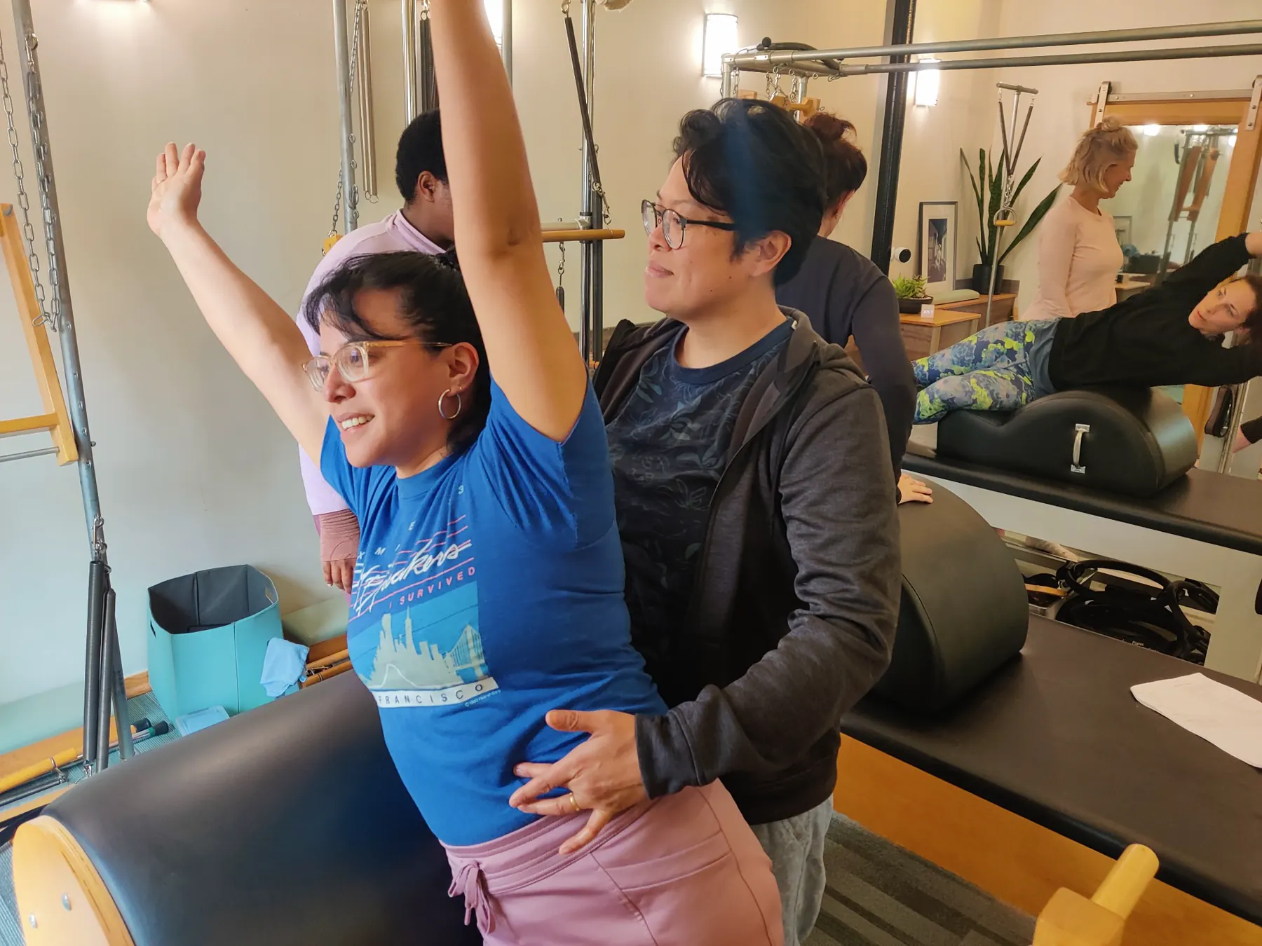 Pilates teacher providing hands-on guidance to a student
